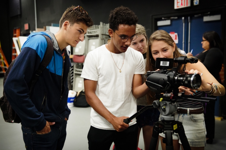 Three students with a film camera.